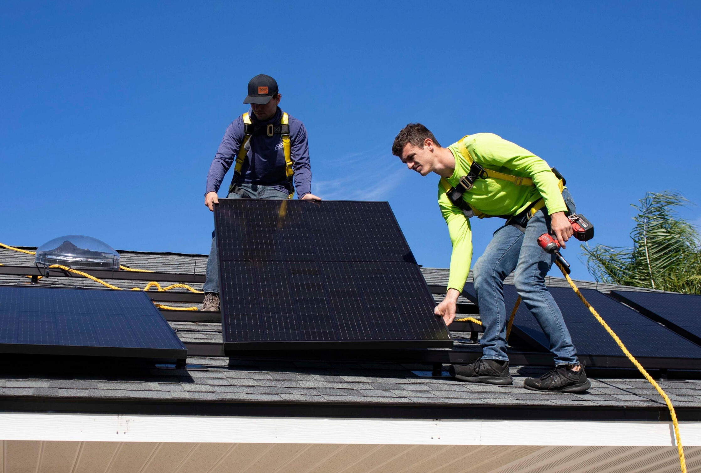 workmen install solar panels on a residential house